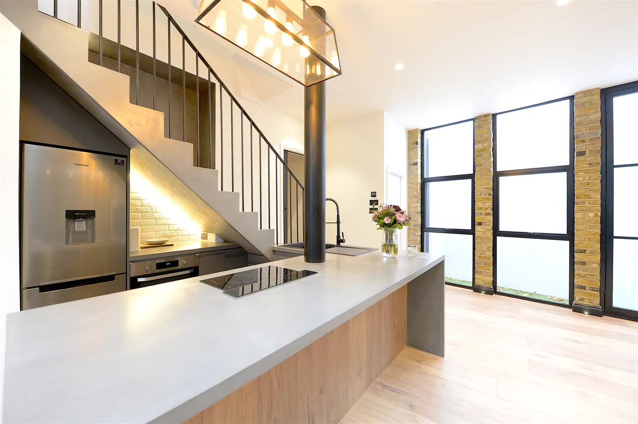 Kitchen island in stone and oak, under the run of the stair