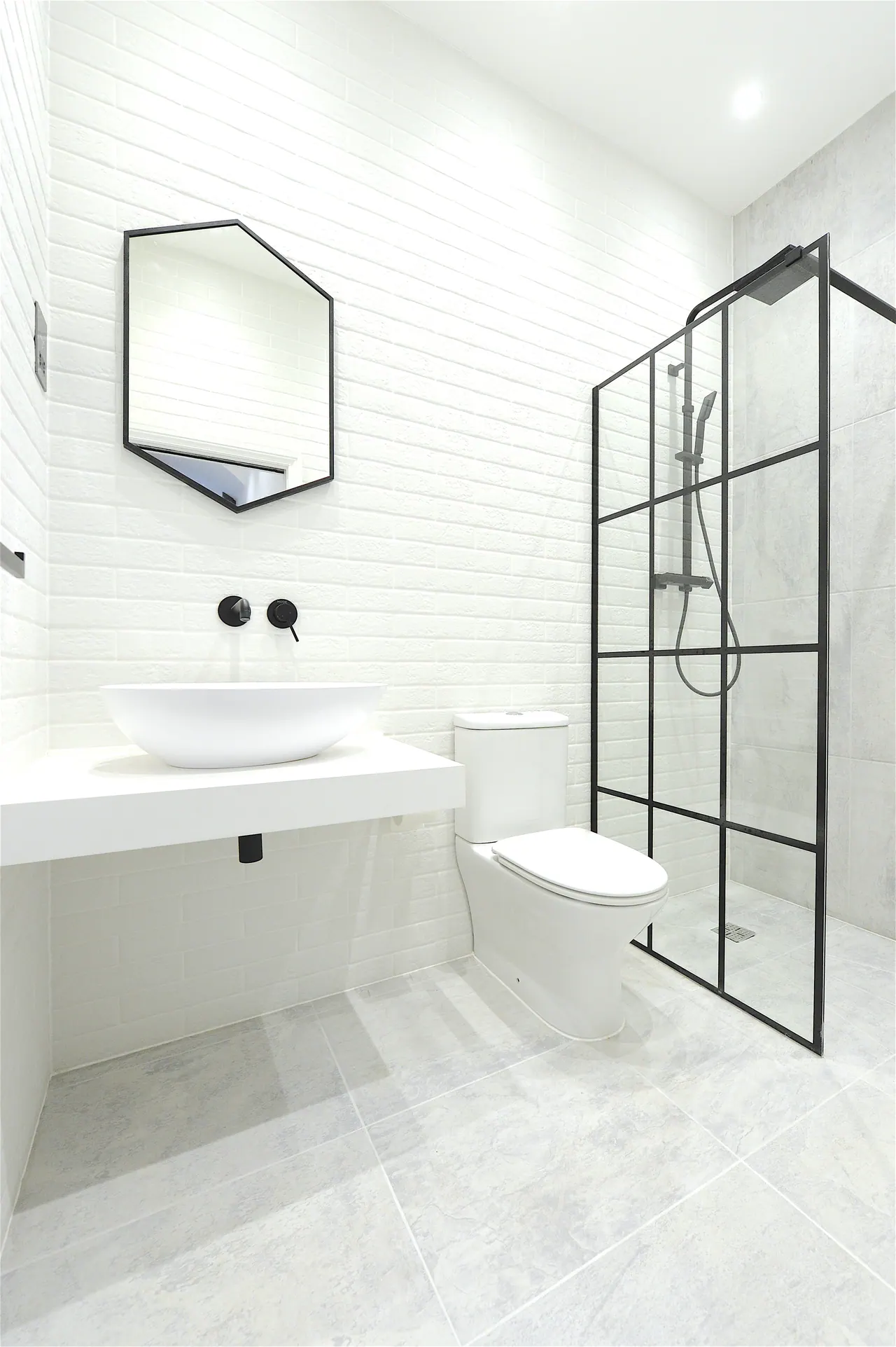 Shower room in marble, with a steel-framed screen